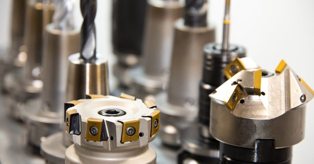 detailed view of various metal drill bits and tools arranged in a workshop setting